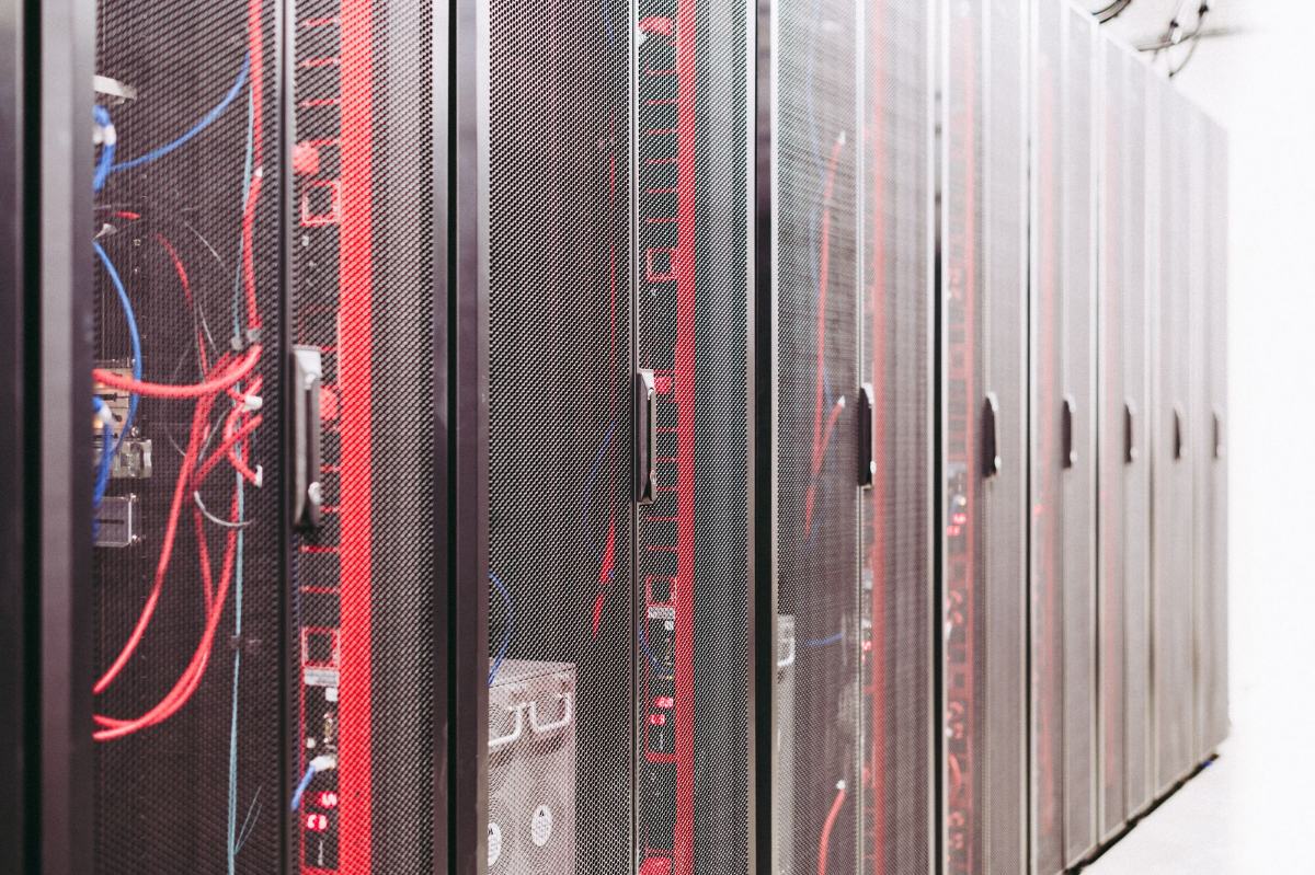 Reihe geschlossener Serverschränke mit perforierten Türen in einem Rechenzentrum